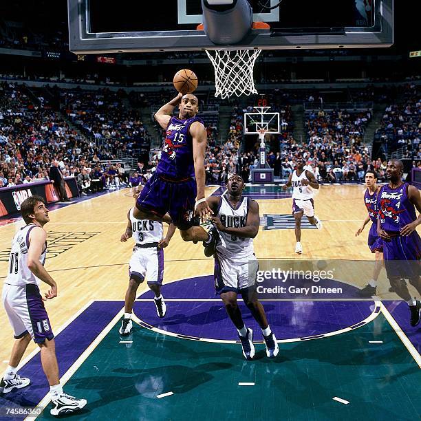 Vince Carter of the Toronto Raptors soars for a dunk during a 1999 NBA game against the Milwaukee Bucks at the Bradley Center in Milwaukee,...