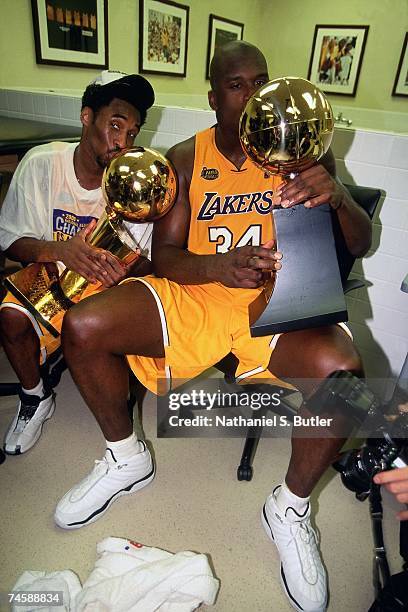 Shaquille O'Neal and Kobe Bryant of the Los Angeles Lakers pose with their trophies after defeating the Indiana Pacers to win the 2000 NBA...