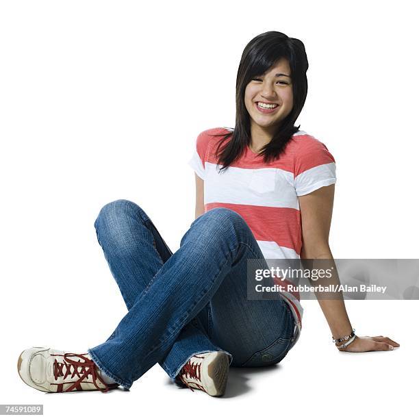 girl sitting cross legged smiling - alleen één tienermeisje stockfoto's en -beelden