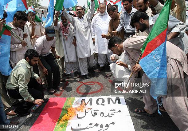 Activists of Pakistan?s hardline Muttahida Majlis-e-Amal torch a flag of pro-Musharraf party Muttahida Qaumi Movement during a protest rally in...
