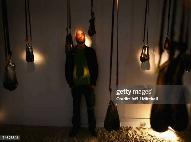 Ramon Beaskoetxea a BA honours student, at Edinburgh college of Art, stands with his art installation of hanging glass bulls testicles June 15, 2007...