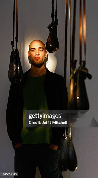 Ramon Beaskoetxea a BA honours student, at Edinburgh college of Art, stands with his art installation of hanging glass bulls testicles June 15, 2007...