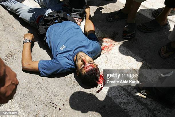 Palestinians look a the body of a member of the Preventative Security Force, loyal to the Palestinian president Mahmoud Abbas on June 14, 2007 in...