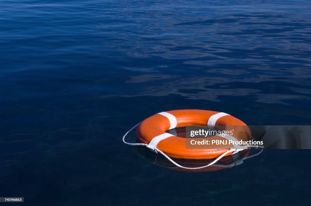 Round life preserver floating in water