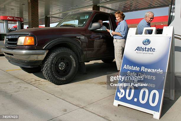 Allstate employees fill the tank of a car during a free gas promotion at a gas staion June 14, 2007 Warren, Michigan. Hundreds of motorists lined up...