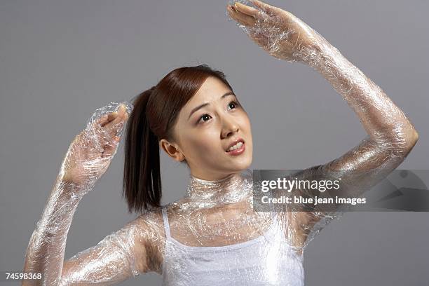 young woman in white and plastic wrap - cellophane photos et images de collection