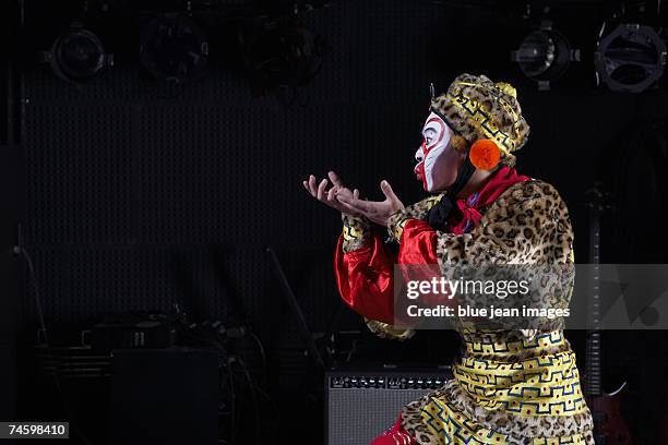 young actor dressed as monkey king poses on stage in front of an amplifier and stage lights. - chinese opera makeup stock pictures, royalty-free photos & images