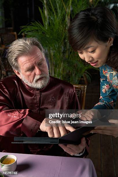 man tells waitress his menu selection at a chinese restaurant. - waitress booth stock pictures, royalty-free photos & images