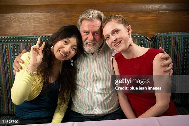 portrait of a man and two women at a chinese restaurant. - waitress booth stock pictures, royalty-free photos & images