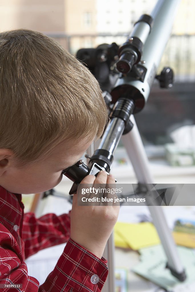 Elementary school boy uses a telescope