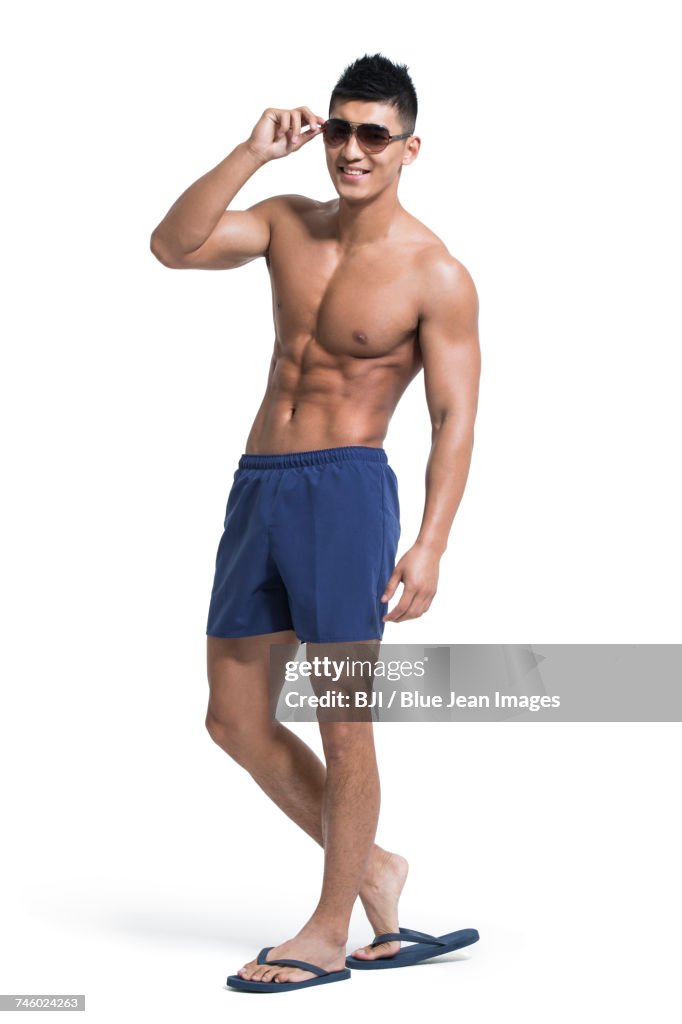 Young muscular man wearing swimming trunks