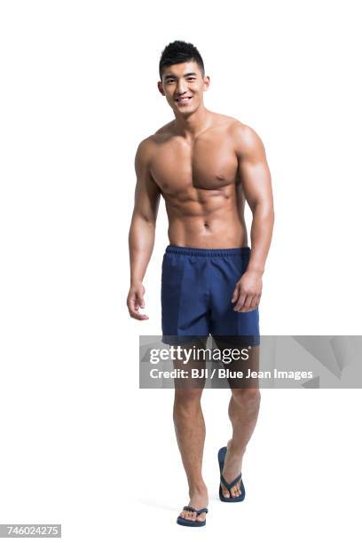 young muscular man wearing swimming trunks - swimwear ストックフォトと画像