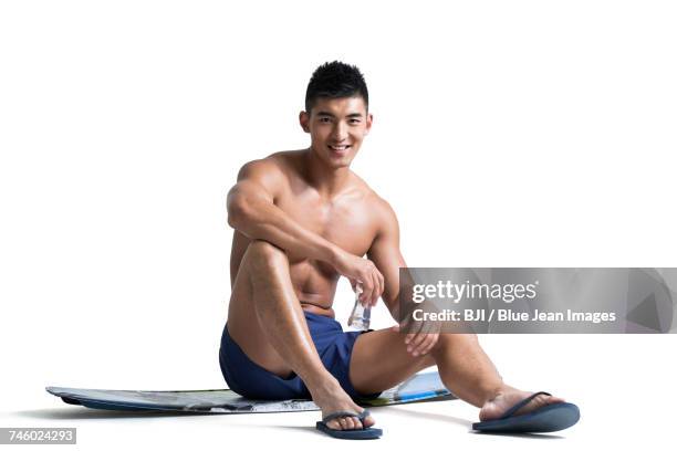 young muscular man holding a bottle of water - handsome stock pictures, royalty-free photos & images