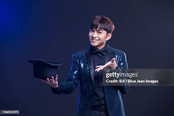 young magician performing magic trick - magician disappear stock pictures, royalty-free photos & images