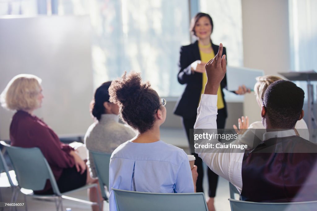 Businesswoman leading conference presentation, answering audience questions