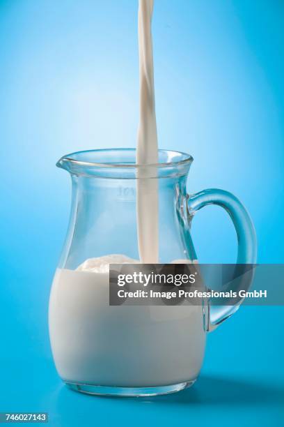 pouring milk into a glass jug - milk stream stock pictures, royalty-free photos & images