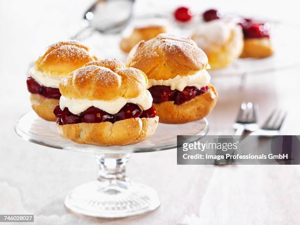 profiteroles filled with cherries and cream - choux pastry stock pictures, royalty-free photos & images