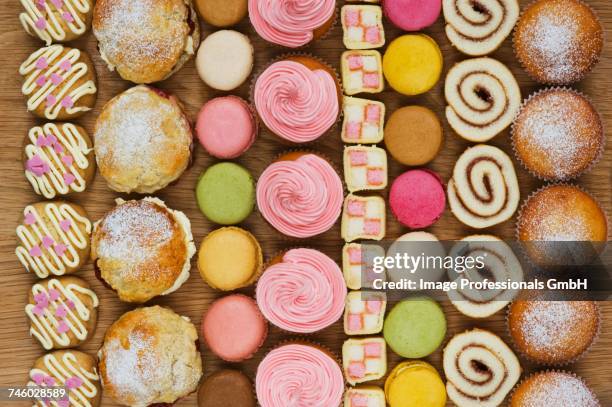 rows of cupcakes, scones, macarons, swiss rolls and pieces of mini-battenburg cake - battenburg fotografías e imágenes de stock