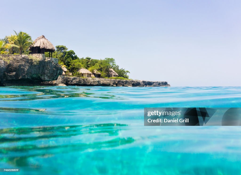 Jamaica, Negril, Traditional huts on rocky coastline