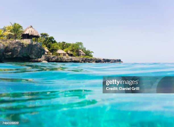 jamaica, negril, traditional huts on rocky coastline - jamaika stock pictures, royalty-free photos & images