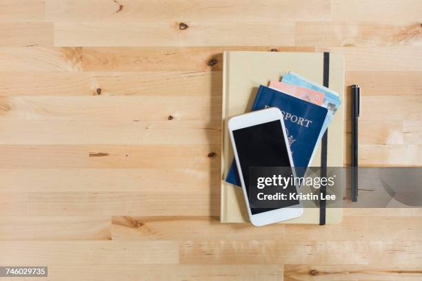 diary, passport with paper currency, smart phone and pen on wooden table - phone still life stock pictures, royalty-free photos & images
