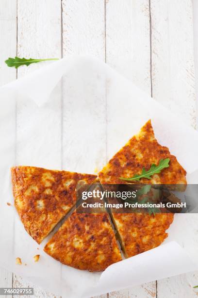 potato tortilla with rocket, cut into slices - tortilla de patata fotografías e imágenes de stock