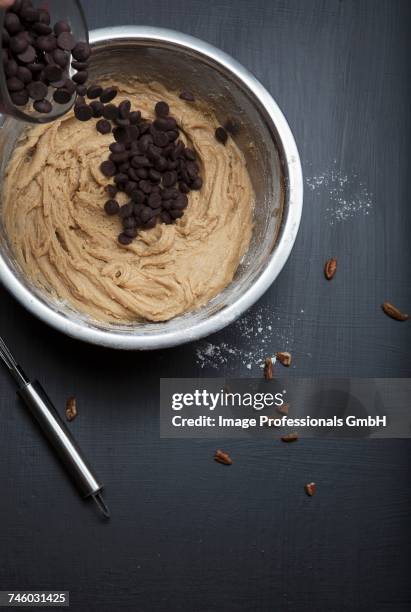 chocolate chip cookie dough in a mixing bowl with wooden spoon - kuchenteig stock-fotos und bilder