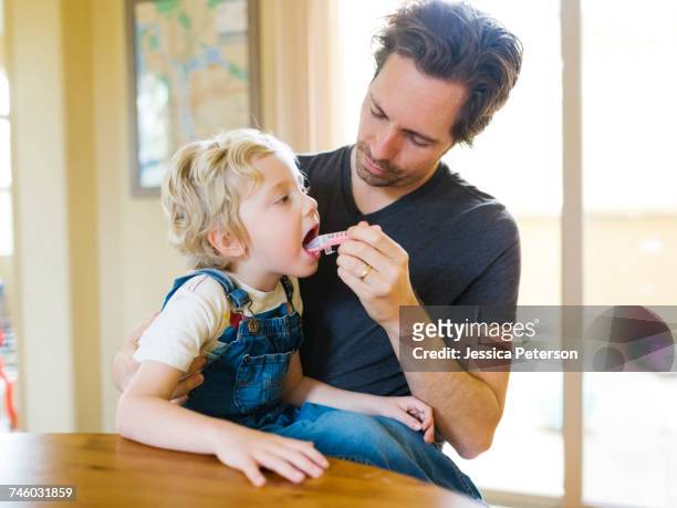 father giving son (4-5) antibiotic - antibiotic stock-fotos und bilder