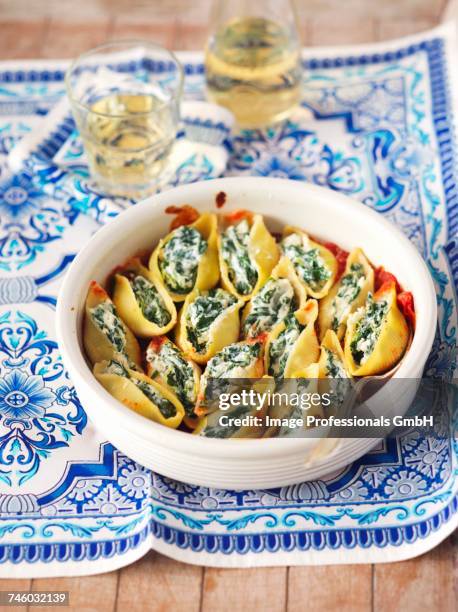 gratinated conchiglie with spinach and feta in tomato sauce - fetta stockfoto's en -beelden