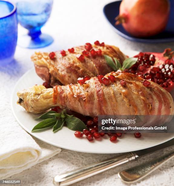turkey legs wrapped in bacon with pomegranate seeds and sage - turkey leg stock pictures, royalty-free photos & images
