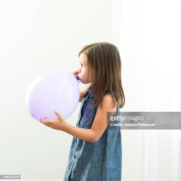 girl (6-7) blowing balloon - balloon girl fotografías e imágenes de stock