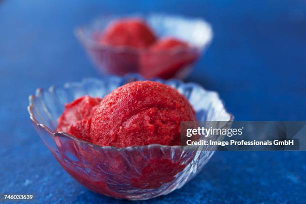 strawberry sorbet in glass bowls on a blue surface - raspberry sorbet stock pictures, royalty-free photos & images