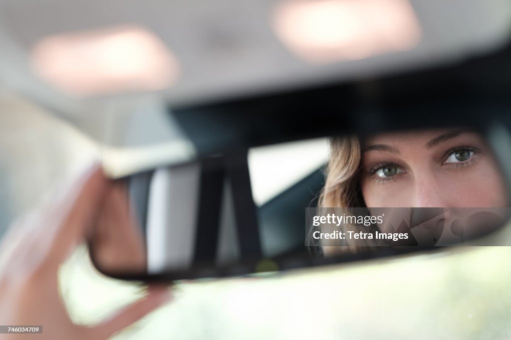 Woman face reflected in rearview mirror