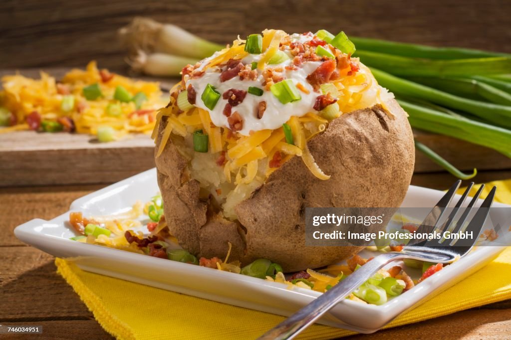 A twice baked potato with Cheddar cheese, onions, sour cream and bacon