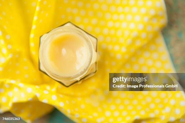 a jar of homemade lemon curd on a yellow surface - vitreous stock pictures, royalty-free photos & images