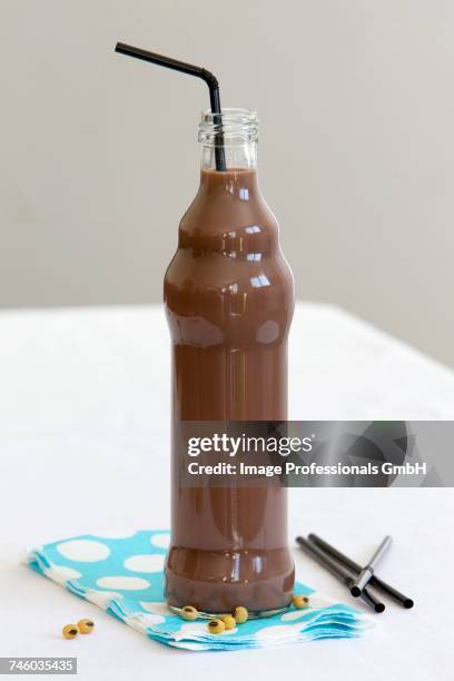 a small bottle of chocolate soya milk with a straw - chocolate milk bottle stock pictures, royalty-free photos & images