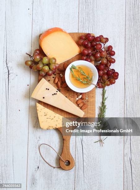 a cheeseboard with grapes, almond olive oil and rosemary - cheese plate stock pictures, royalty-free photos & images