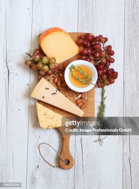 a cheeseboard with grapes, almond olive oil and rosemary - ostbricka bildbanksfoton och bilder