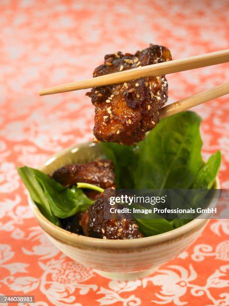 sweet and sour pork with sesame seeds and spinach shoots - sweet and sour pork ストックフォトと画像