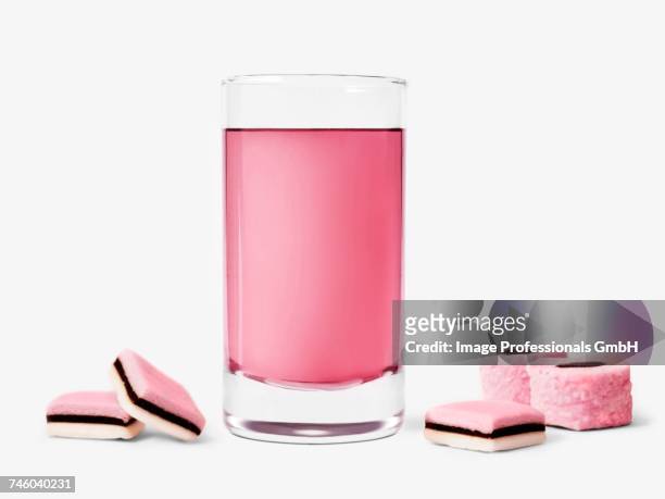 glass of rose syrup and licorice candies - licorice flower stock pictures, royalty-free photos & images