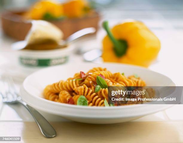 tomato fusilli pasta - gele paprika stockfoto's en -beelden