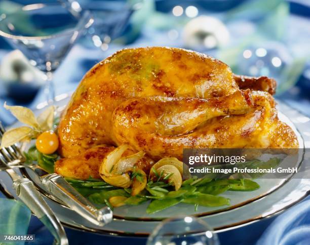 roast capon garnished with truffles and served with spicy sugar peas - boule noel stock-fotos und bilder