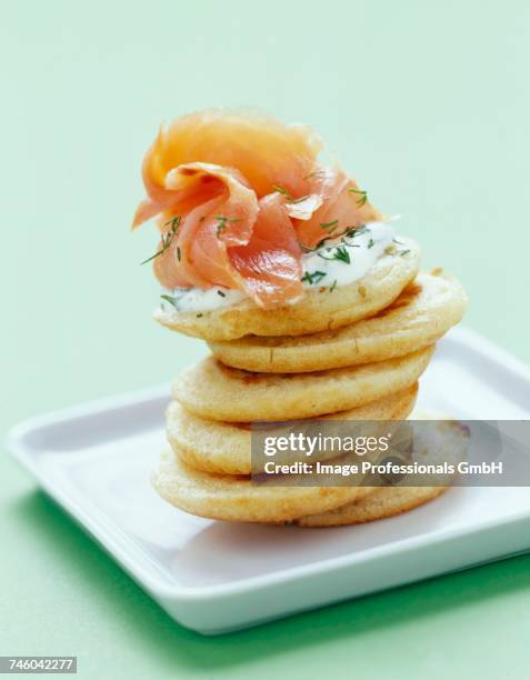 smoked salmon and herb cream on mini blinis - canap�� fotografías e imágenes de stock