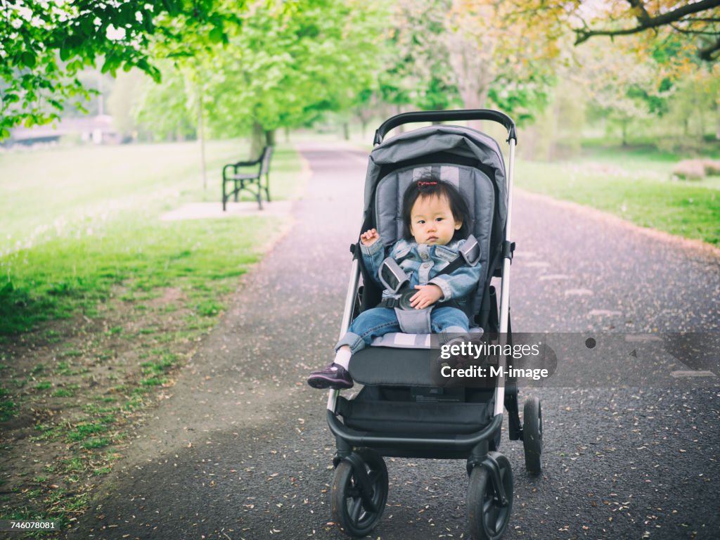 Portrait De Petite Fille En Poussette Sur La Route Au Parc