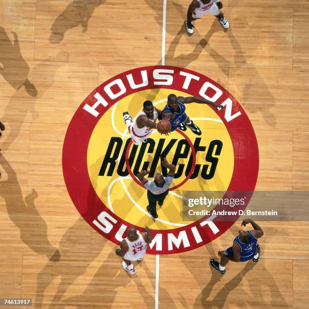 Hakeem Olajuwon of the Houston Rockets battles for a jumpball against Shaquille O'Neal of the Orlando Magic during a 1995 NBA game at the Houston...