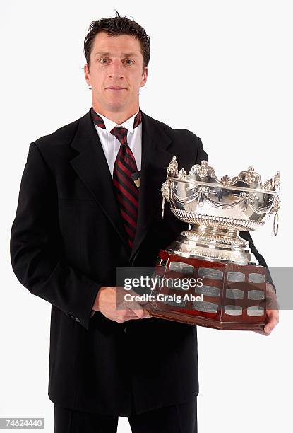 Rod Brind'Amour of the Carolina Hurricanes poses for a portrait backstage with the Frank J. Selke Trophy for Top Defensive Forward in the NHL during...