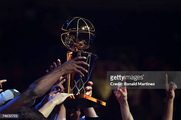 Members of the San Antonio Spurs hold up the Larry O'Brien Championship Trophy after winnin Game Four of the NBA Finals against the Cleveland...