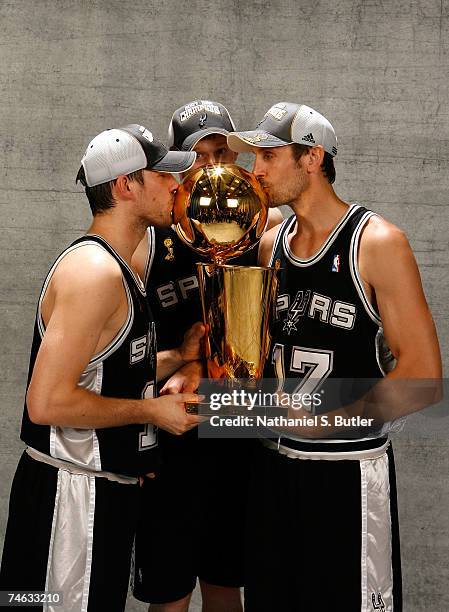 Beno Udrih, Matt Bonner Brent Barry of the San Antonio Spurs pose for a portrait with the Larry O'Brien Championship trophy after they won the 2007...