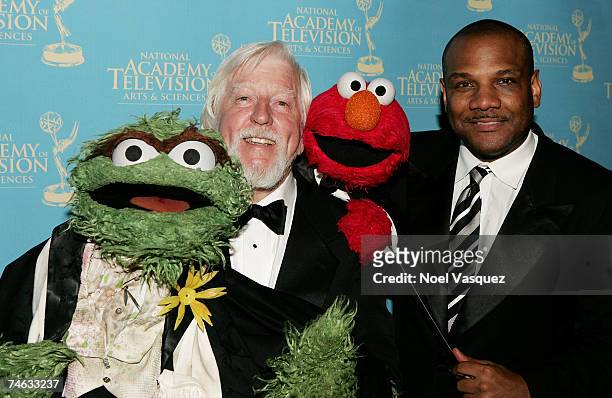 Actors/Puppeteers Caroll Spinney and Kevin Clash, with their respective personalities "Oscar the Grouch" and "Elmo", pose in the press room during...
