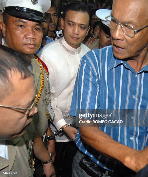 Philippine Senator Rodolfo Biazon orders soldiers to remove the handcuffs on detained Philippine navy lieutenant, Antonio Trillanes , as he arrives...